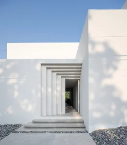 Clean, minimalist home exterior with white walls and concrete steps