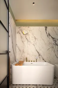 Modern bathroom interior with white marble walls and a freestanding bathtub.