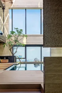 An elegant indoor swimming pool with modern design elements, including concrete, glass, and stainless steel.