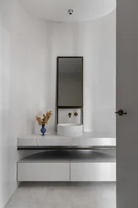 A minimalist bathroom with a marble sink, counter, and mirror.