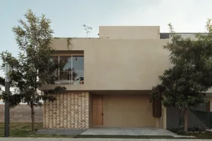 A modern concrete house exterior with a minimalist design and large windows.