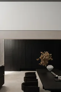 A modern living room featuring black wooden furniture and minimalist decor.