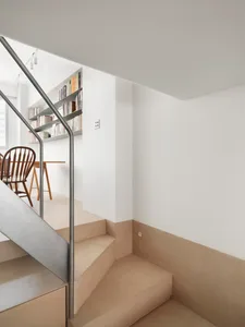 A modern staircase with concrete flooring, viewed from the interior.