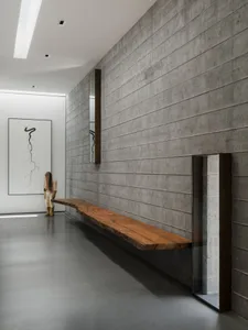 A sleek, modern lobby featuring a long, floating wooden bench against a textured concrete wall.