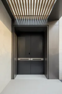Modern black doorway with minimalist design, featuring a sleek metal door with horizontal lines and a simple rectangular fram