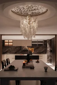 Modern kitchen featuring a marble backsplash and island with a centerpiece vase containing orange flowers and a black sculptu