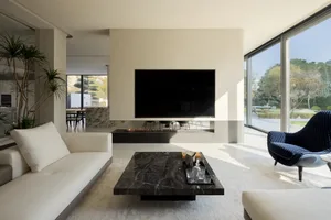 Image of a modern living room with a concrete fireplace and black marble coffee table.
