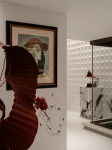 A stylish indoor space featuring a red decorative piece and framed art hanging on the wall.