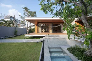 A modern house exterior featuring wood, glass, and concrete materials.