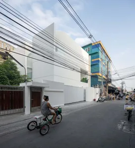 Modern building with white concrete exterior, street view with bicycles and power lines