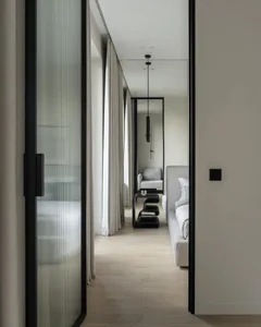 Modern minimalist lounge area with recessed lighting and glass partitions.