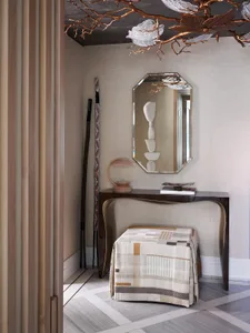 Modern entrance hall featuring mixed materials and elegant furnishings.