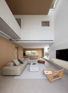 Modern minimalist living and dining room featuring concrete, wood, and leather elements.