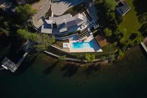 A modern residential architectural design featuring stone and wooden elements.