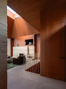 A modern accent room with wooden walls featuring a lounge area and a television.