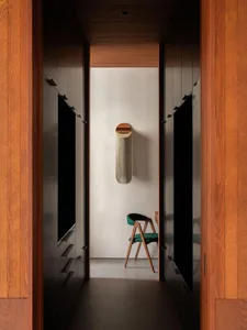 A simple, minimalist bathroom featuring concrete walls and wooden flooring and cabinetry.