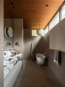 Modern bathroom featuring tile and concrete materials, clean lines, and natural light.