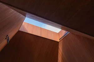 Low-angle view of a modern contemporary interior with wooden walls and a wooden skylight