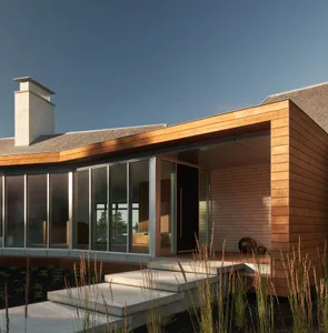 Modern residential house with wooden exterior and large windows.