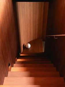 A wooden staircase with a basketball ball on the step.