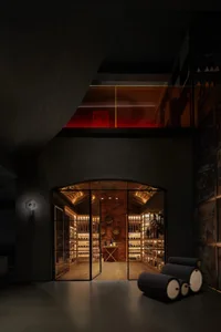 Industrial-style wine cellar featuring brick walls, glass display cases, and metal accents.