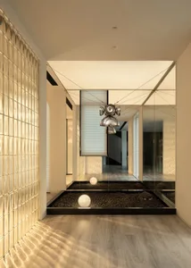 Modern living room with glass block wall, wooden flooring, and minimalist decor.