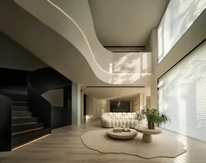 Modern living room with minimalist design, featuring a white sofa, round coffee table, and curved staircase with black railin