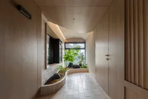Minimalist interior space with wooden walls and a small indoor garden.