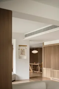 A modern living room with white walls, wooden furniture, and minimalistic decor.