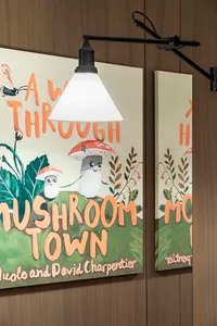 A mural featuring cheerful mushroom characters on a green hill in a children's room setting.