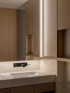 A modern bathroom with marble countertop and sink.