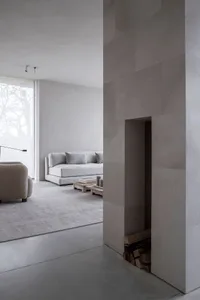 A minimalist living room with concrete walls and floor.