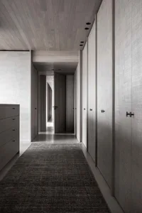 Interior shot of a modern walkway with wooden walls and floors, closed doors, and minimalistic design.