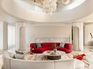 A modern living room with a red sofa on a round rug.