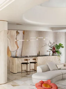 Modern residential interior with marble kitchen island and light wood furnishings.