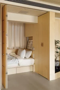 Modern minimalist bedroom with a bed, pillows, and a window.
