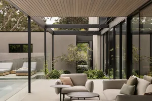 A modern exterior space featuring concrete, glass, and wooden elements.