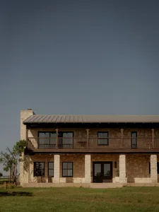 A two-story ranch house with a stone exterior and metal roof.