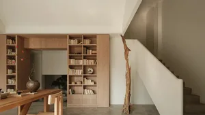 A minimalist living room with wooden shelves and a concrete floor.