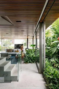 A modern living room featuring a glass door and green plants.