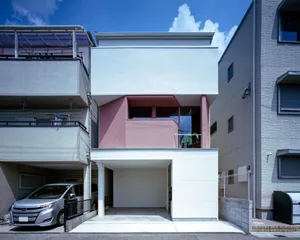 一座現代簡約風格的兩層混凝土外觀住宅，位於都市環境中。
