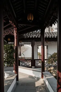 A traditional Japanese veranda with wooden beams, metal railings, and nature-inspired landscaping.