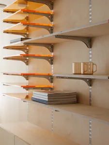 Modern interior design featuring sleek wooden shelving units with metallic brackets.