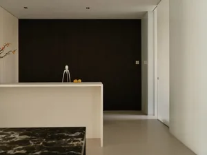 Modern minimalist residential kitchen featuring marble countertops and wooden cabinetry.