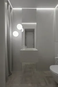 Modern minimalist bathroom with concrete surfaces, glass shower enclosure, and metal fixtures.