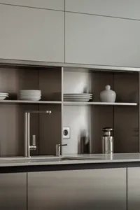A modern residential kitchen featuring metallic surfaces and sleek design elements.