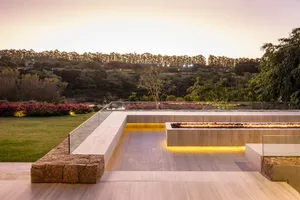 Modern outdoor living area featuring stone materials and a fire pit at dusk.