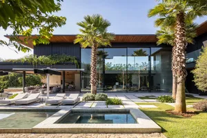 Modern residential architecture featuring glass walls and wood accents.