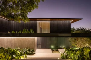A modern residential building with metal accents and glass panels.