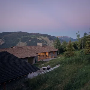A modern residential exterior with a wooden roof and stone walls.